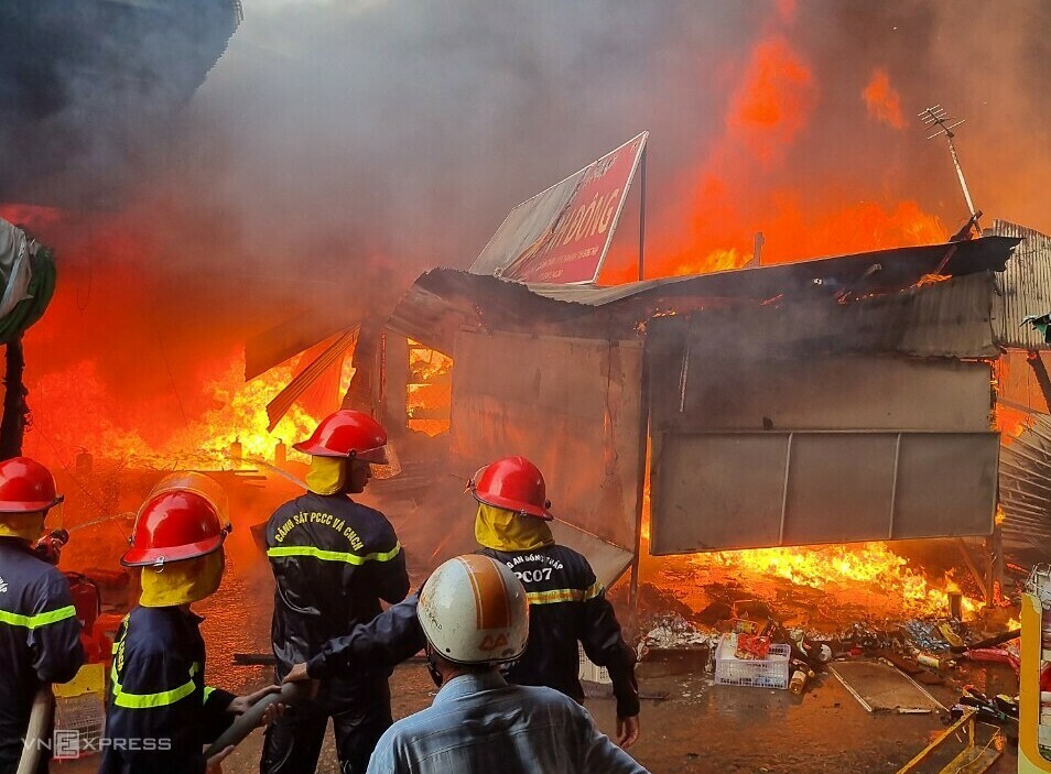 Cảnh sát dùng vòi rồng dập lửa tại chợ Bình Thành sáng 22/4. Ảnh: Ngọc Tài