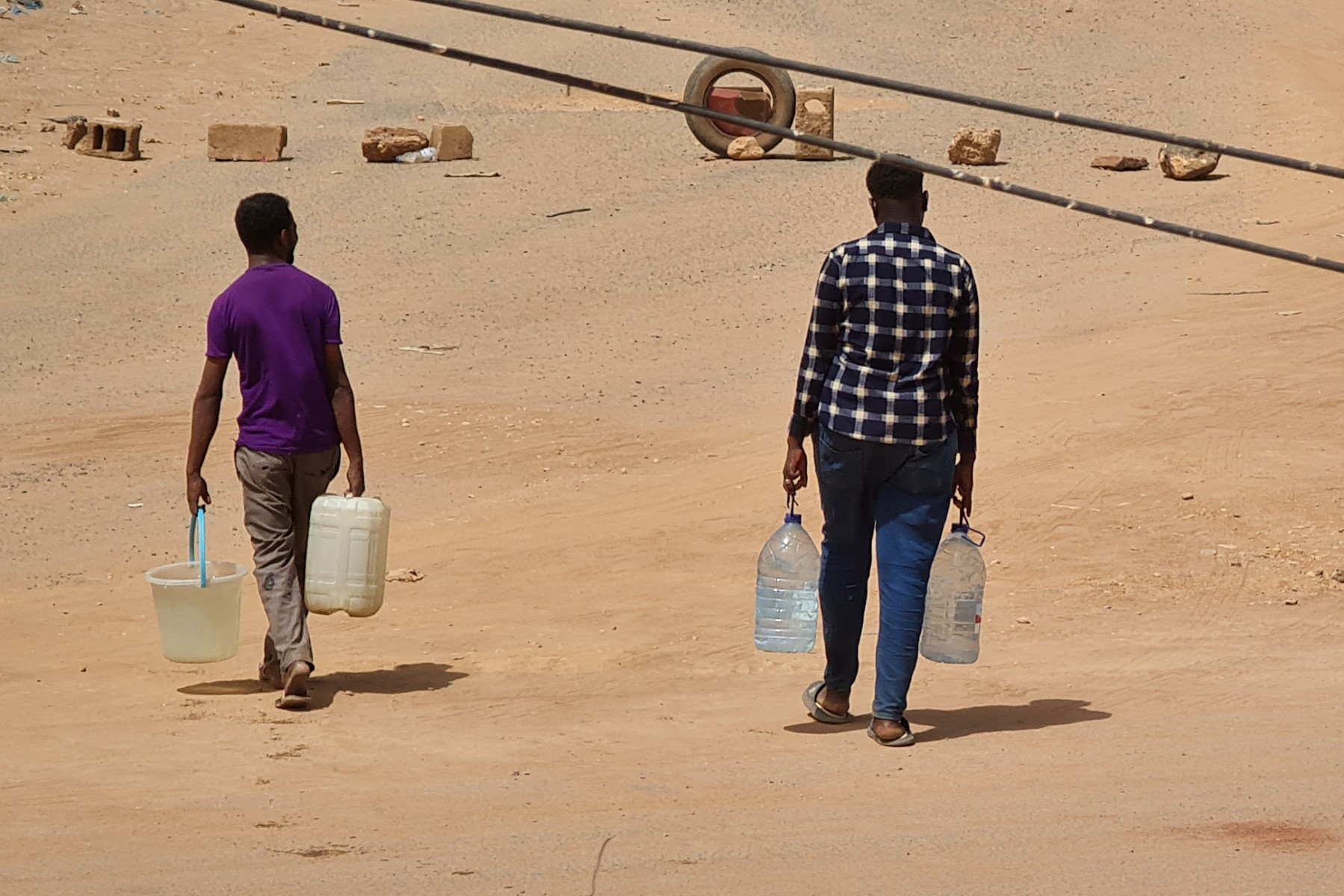 Người dân Sudan xách nước về nhà ở Khartoum ngày 25/5. Ảnh: AFP