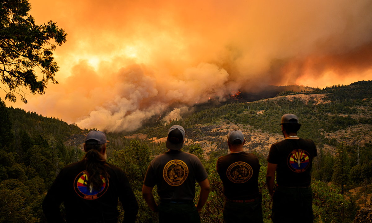 Lực lượng cứu hỏa quan sát đám cháy tại hạt Butte từ xa hôm 26/7. Ảnh: AFP