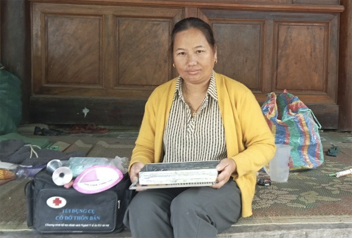 Chị Xồng Y Trử bên bộ đồ nghề của cô đỡ thôn bản. Ảnh: Hùng Lê