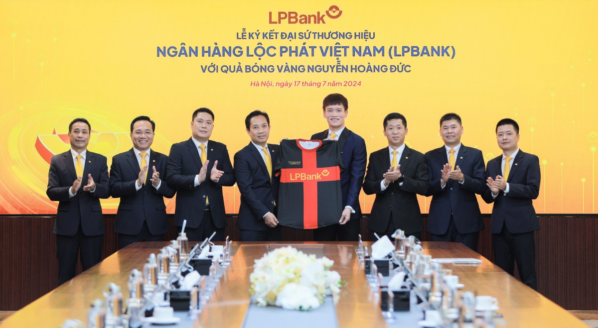 Ông Lê Minh Tâm, Phó chủ tịch thường trực Hội đồng quản trị LPBank (trái) trao trang phục cho cầu thủ Hoàng Đức tại lễ công bố đại sứ thương hiệu Ngân hàng Lộc Phát Việt Nam (phải). Ảnh: LPBank