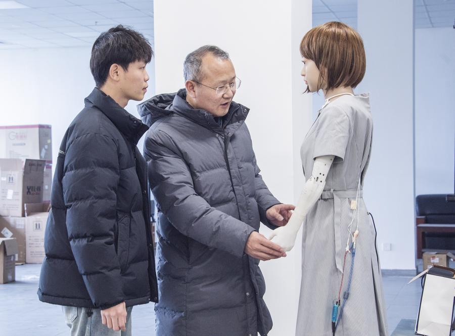 202408016ad1e07a19c44b40af7fc6-8759-3650-1722766969 Giáo sư Liu Xiaofeng nói chuyện với một nghiên cứu sinh về robot hình người tại Đại học Hà Hải. Ảnh: Xinhua