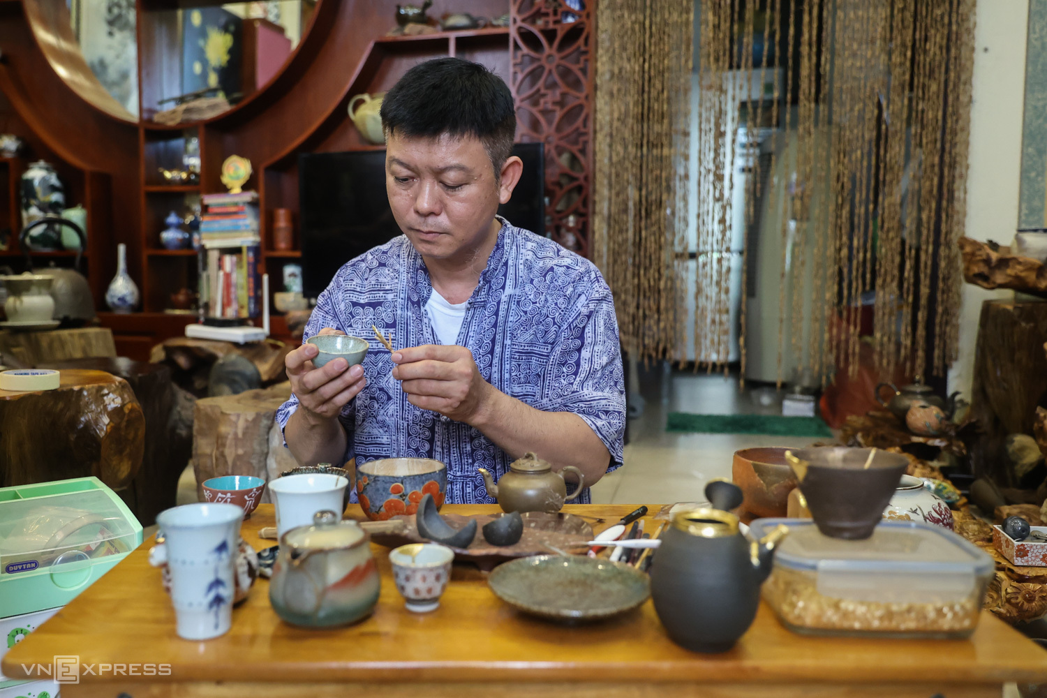 Mỗi ngày anh Viễn dành từ 5 đến 6 tiếng để sửa đồ gốm. Ảnh: Quỳnh Trần