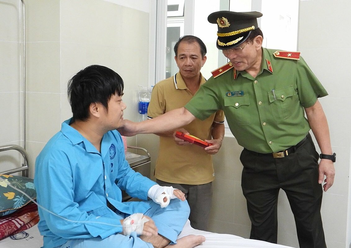 Một trong hai cán bộ công an bị Sách tấn công, bị thương ở tay được Giám đốc Công an TP Đà Nẵng thăm hỏi, động viên. Ảnh: Văn Hồ