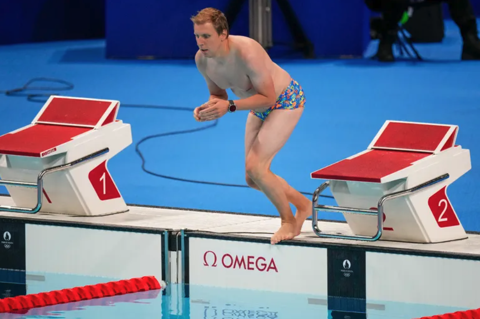 Nam nhân viên nhảy xuống bể để vớt mũ cho kình ngư Emma Weber. Ảnh: AP