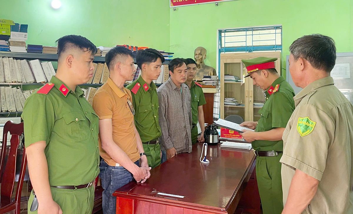 Cảnh sát đọc lệnh bắt giữ Phi và Kha. Ảnh: Công an cung cấp