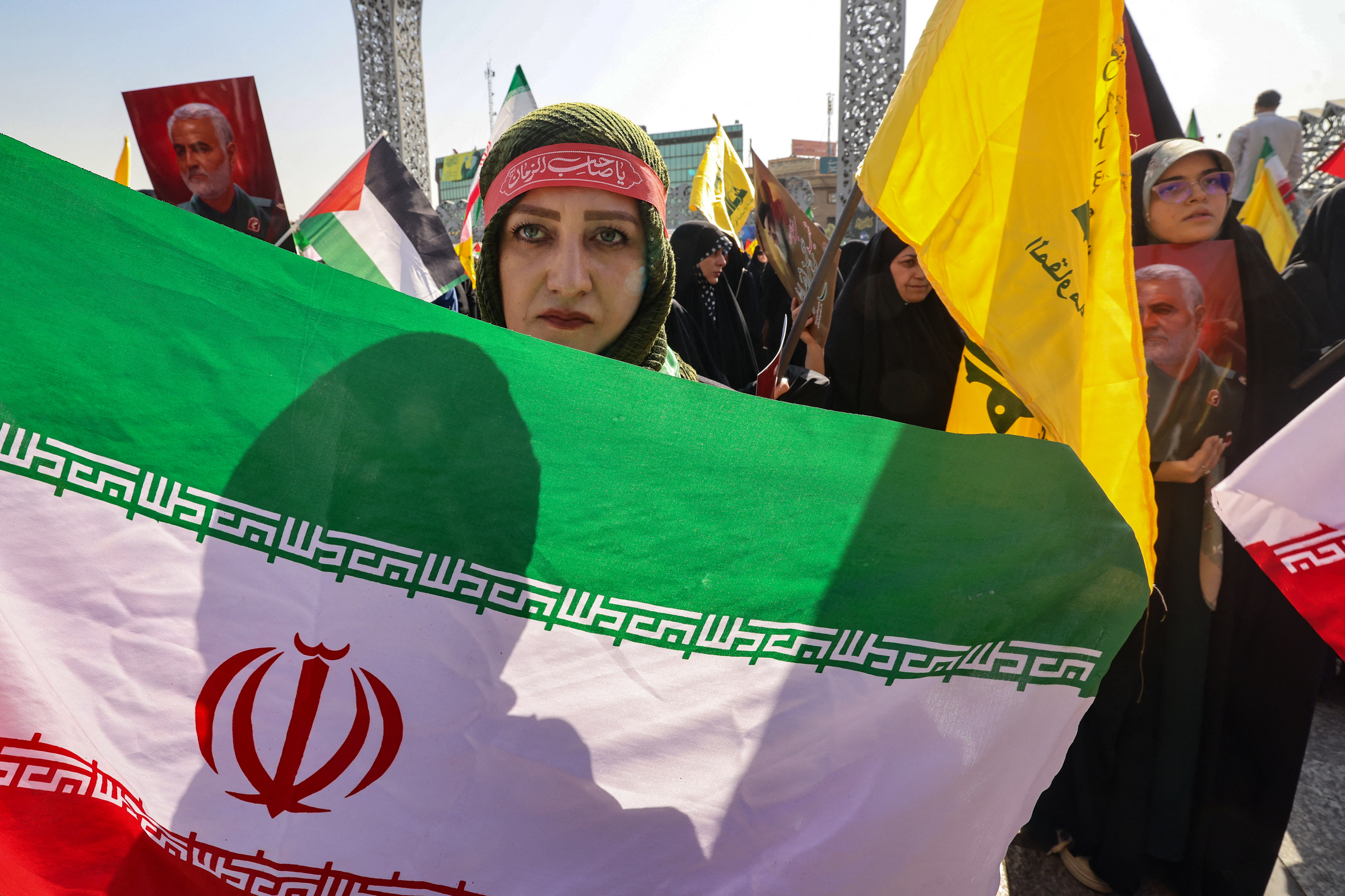 Người phụ nữ cầm cờ Iran diễu hành trên phố Tehran ngày 2/10. Ảnh: AFP