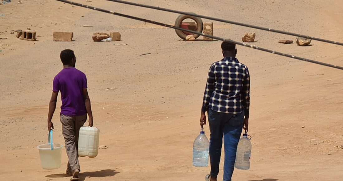 Người dân Sudan xách nước về nhà ở Khartoum ngày 25/5. Ảnh: AFP