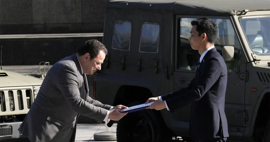 Thứ trưởng Quốc phòng Nhật Bản Toshiro Ino (phải) trao tài liệu cho đại sứ Ukraine Sergiy Korsunsky trong buổi lễ ở Tokyo ngày 24/5. Ảnh: AP