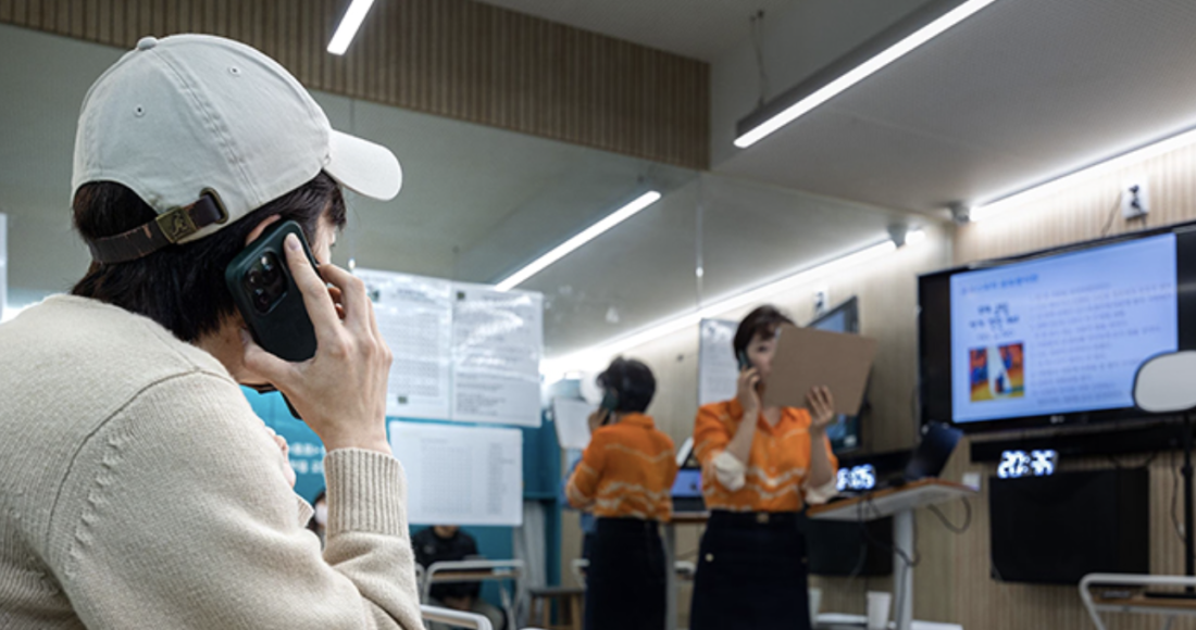 Một học viên mô phỏng cuộc trò chuyện qua điện thoại với một người hướng dẫn trong một lớp học giao tiếp ở Seoul, hôm 9/5. Ảnh: Chosun