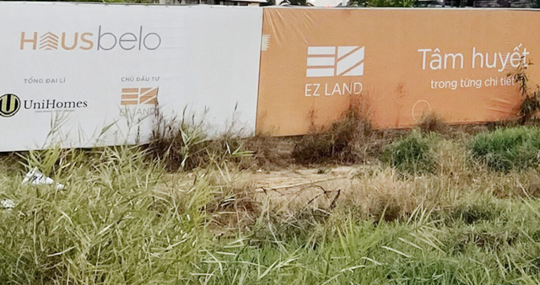 Hàng rào khu đất dự án Hausbelo vẫn còn lưu lại thông tin tên dự án và công bố EZLand (công ty mẹ của Công ty AHC Minh Sơn) là chủ đầu tư dự án. Ảnh: Trung Tín