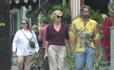 Theron và bạn trai nắm tay, rời khỏi một nhà hàng tại Los Angeles hôm 14/5. Ảnh: BACKGRID