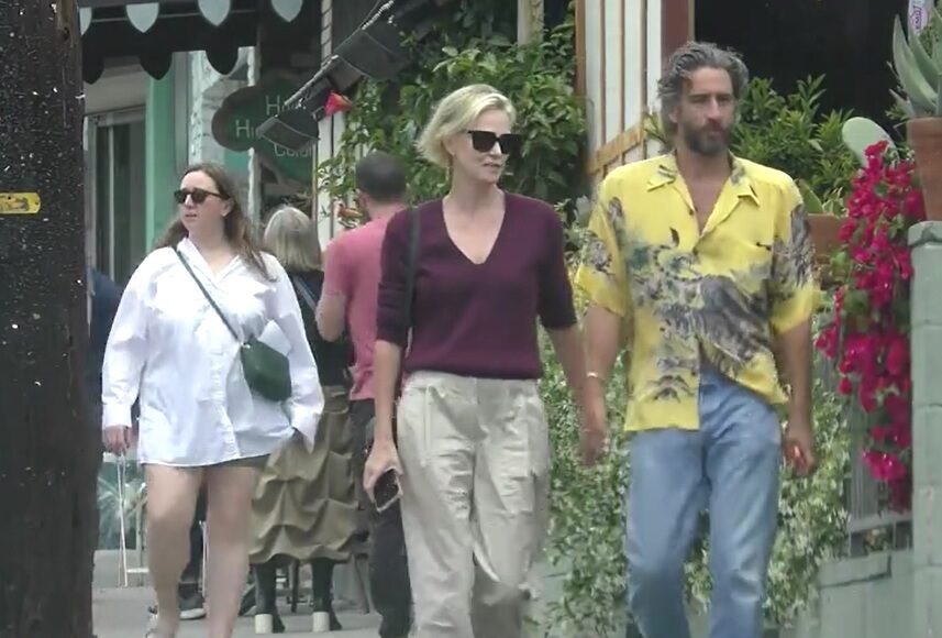 Theron và bạn trai nắm tay, rời khỏi một nhà hàng tại Los Angeles hôm 14/5. Ảnh: BACKGRID