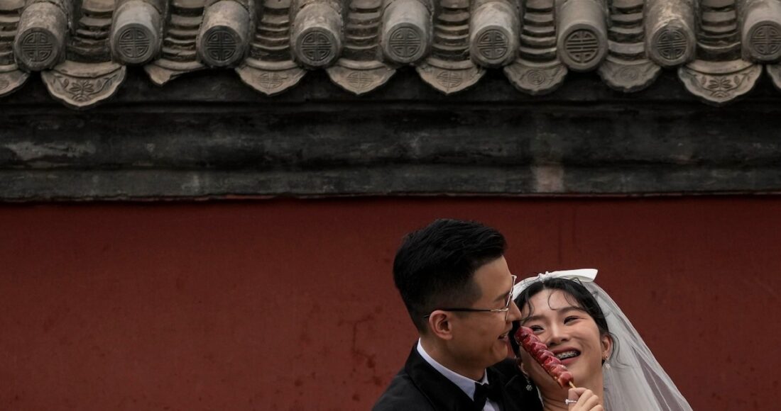 Một cặp đôi đang chụp ảnh cưới ngoài trời ở ngoại ô thủ đô Bắc Kinh, Trung Quốc, tháng 8/2021. Ảnh: AP