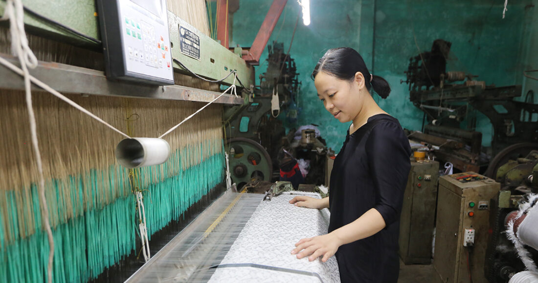 Trần Thị Yến đang kiểm tra những tấm vải đang dệt. Ảnh: Đắc Thành