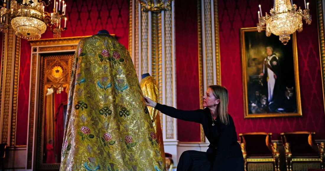 Caroline de Guitaut chỉnh lại Áo choàng Hoàng gia trong Cung điện Buckingham, London, ngày 26/4. Ảnh: Reuters