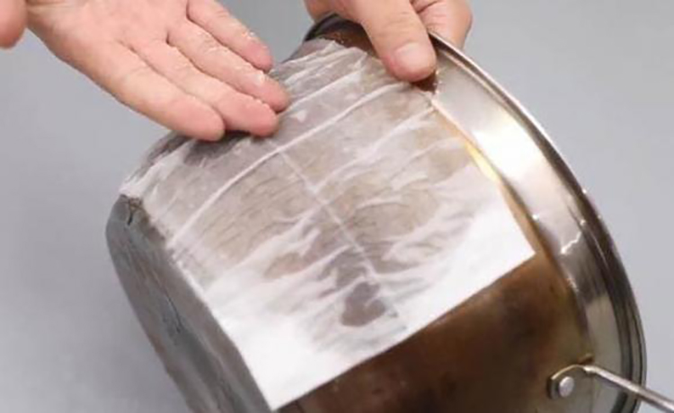 Khăn giấy thấm dung dịch phủ lên nồi inox có tác dụng kéo dài thời gian thẩm thấu. Ảnh: aboluowang