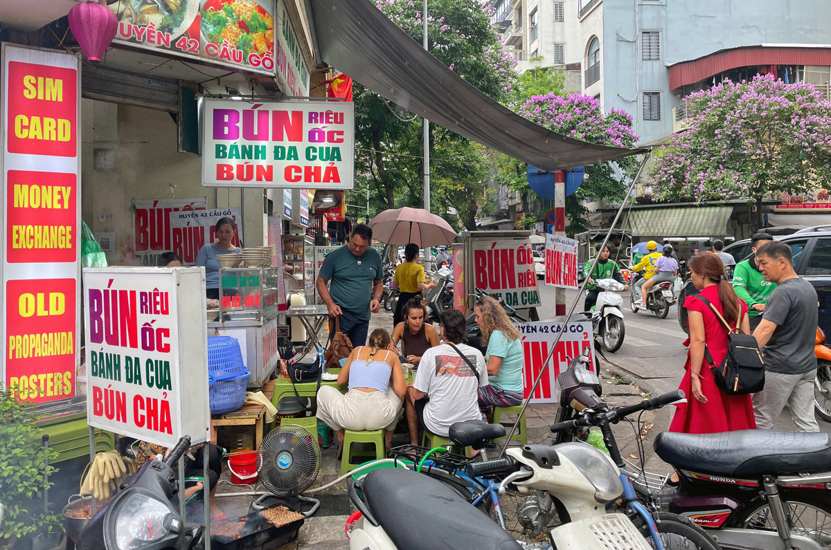 Sáng 14/5, cửa hàng ăn trên phố Cầu Gỗ để biển bảng chiếm vỉa hè, xe máy xe đạp để dưới lòng đường. Ảnh: Giang Huy