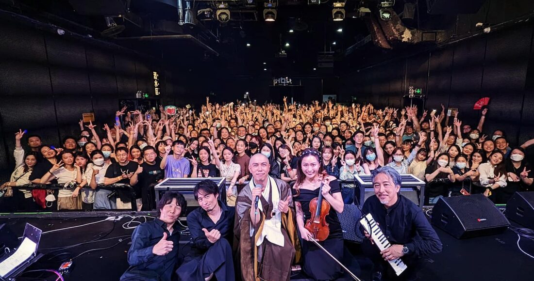 Sư thầy Kanho Yakushiji (giữa) chụp hình cùng ban nhạc và người hâm mộ sau buổi biểu diễn ở Thâm Quyến hôm 16/5. Ông tiếp tục hát ở Quảng Châu (17/5), Hàng Châu (18/5), Thượng Hải (20/5), Bắc Kinh (23, 24/5). Ảnh: Instagram Kanho Yakushiji