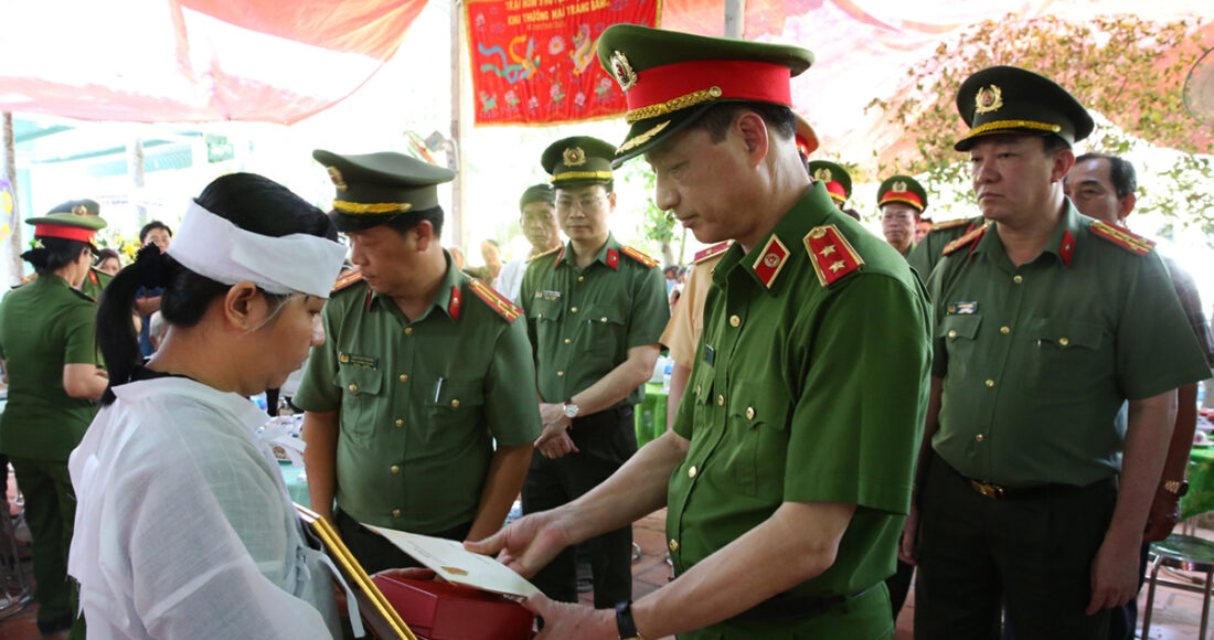 Trung tướng Nguyễn Duy Ngọc, Thứ trưởng Công an, trao quyết định thăng quân hàm cho gia đình trung tá Nguyễn Xuân Hào, hôm 23/4. Ảnh: Thúy Phượng