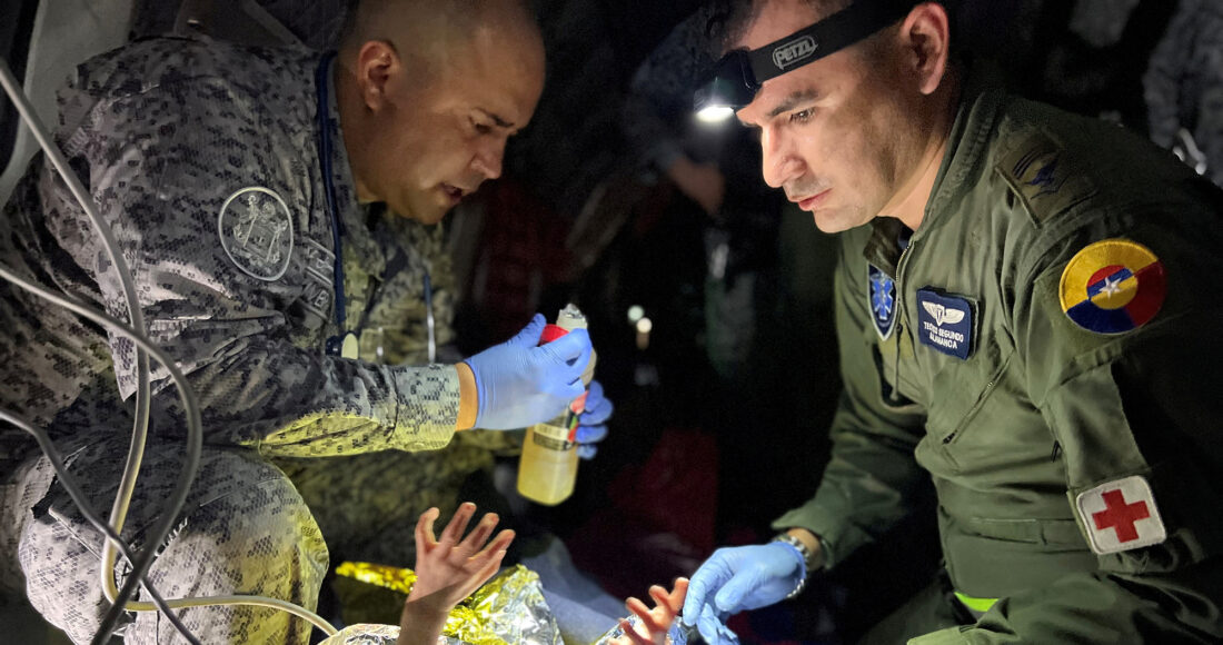 Lính không quân Colombia chăm sóc cho em bé được tìm thấy trong rừng Amazon hôm 9/6. Ảnh: Reuters