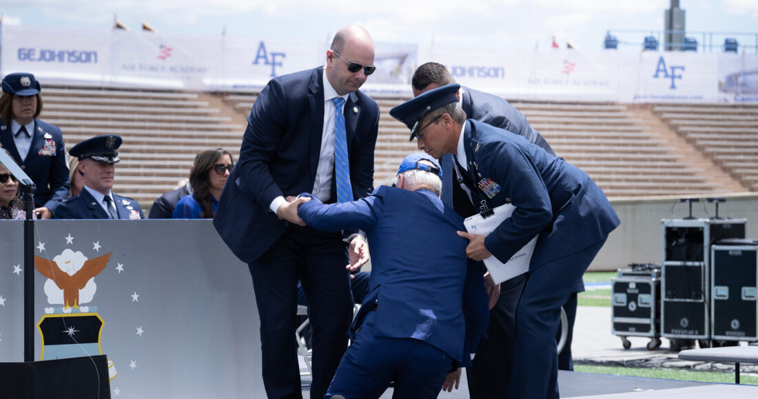 Tổng thống Joe Biden được đỡ đứng dậy sau khi ông vấp ngã trên sân khấu Học viện Không quân, bang Colorado ngày 1/6. Ảnh: AFP