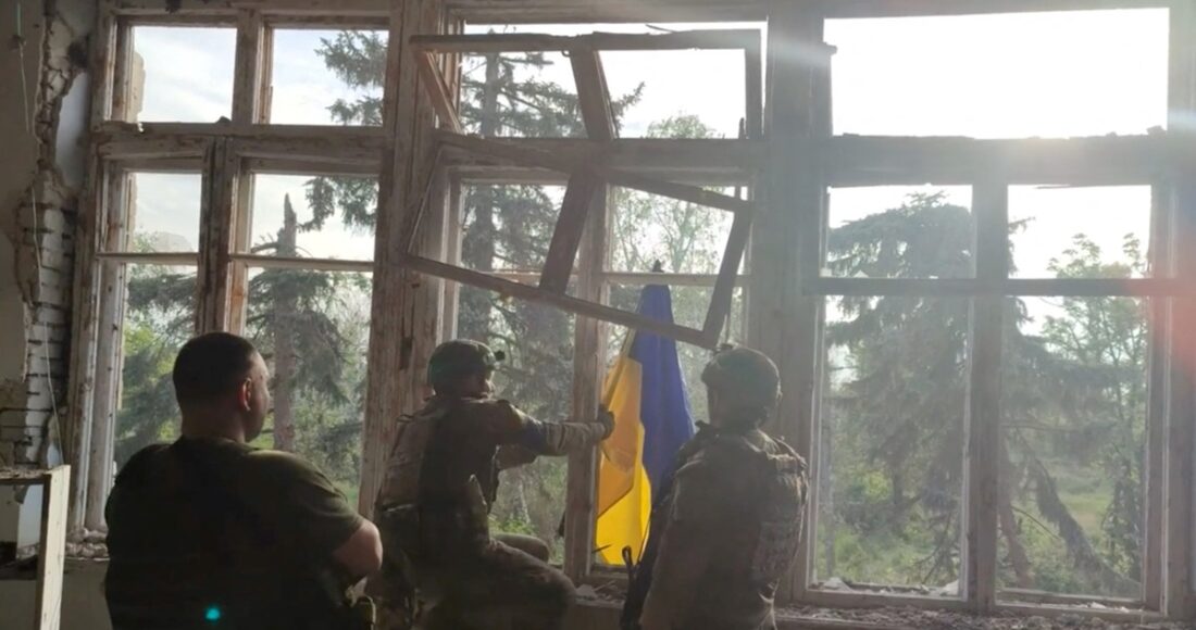 Hình ảnh do Ukraine công bố cho thấy binh sĩ nước này treo quốc kỳ tại làng Blahodatne, vùng Donetsk, hôm 11/6. Ảnh: Reuters