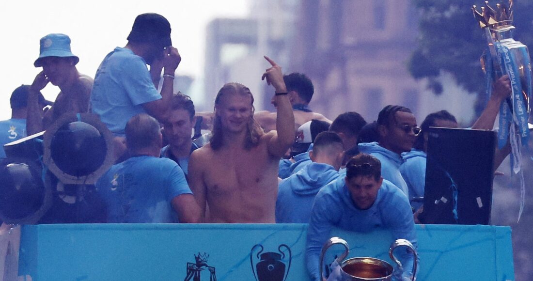 Haaland (cởi trần) phấn khích trong lễ diễu hành trên xe bus mui trần ở Manchester, mừng cú ăn ba của Man City. Ảnh: Reuters