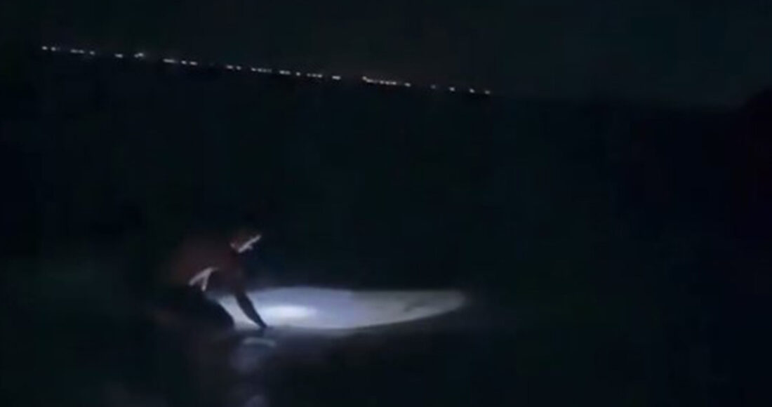 Anh Bách soi đèn bắt còng dọc bờ biển trong đêm. Ảnh: Võ Thạnh