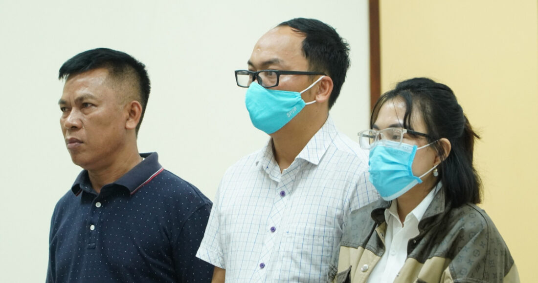 Bị cáo Minh (áo trắng, ở giữa) cùng chú và vợ tại phiên toà. Ảnh: Bùi Nhân