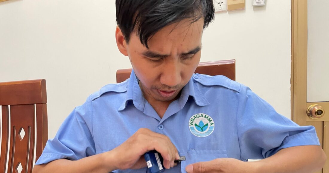 Anh Phan Phước Thắng mang thiết bị đo liều phóng xạ khi làm việc ở cự ly gần máy chiếu xạ tại Vinagamma. Ảnh: Hà An