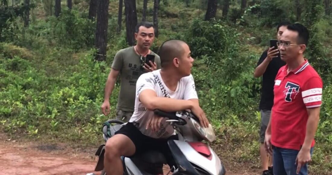 Người dân chặn thanh niên áo trắng hỏi lý do đốt rừng. Ảnh: Vạn An