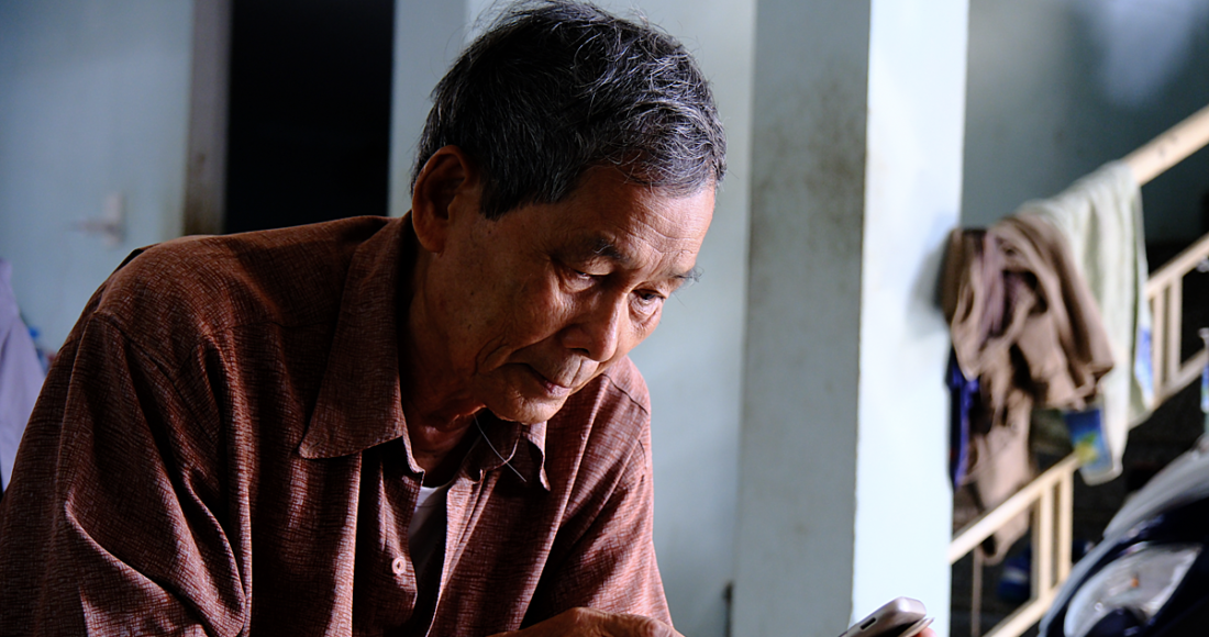 Một người lớn tuổi ở Đà Nẵng làm quen với sử dụng điện thoại thông minh. Ảnh: Nguyễn Đông