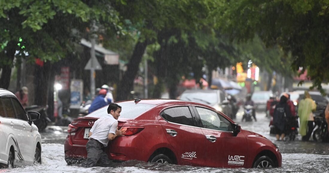 Tài xế đẩy ôtô chết máy ở khu Thảo Điền, TP Thủ Đức qua chỗ ngập. Ảnh: Thanh Tùng
