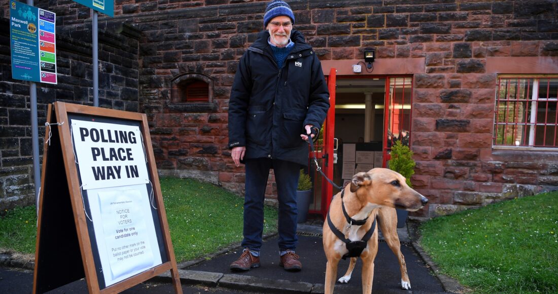 Cử tri dắt chó tới điểm bỏ phiếu ở Glasgow, Anh, ngày 4/7. Ảnh: AFP
