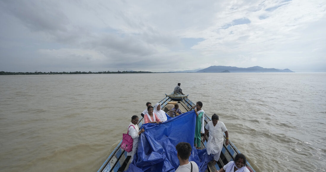 Đội y tế căng bạt và đỡ đẻ cho Jahanara Khatoon trên chiếc thuyền giữa dòng lũ sông Brahmaputra, bang Assam, đông bắc Ấn Độ ngày 3/7. Ảnh: AP