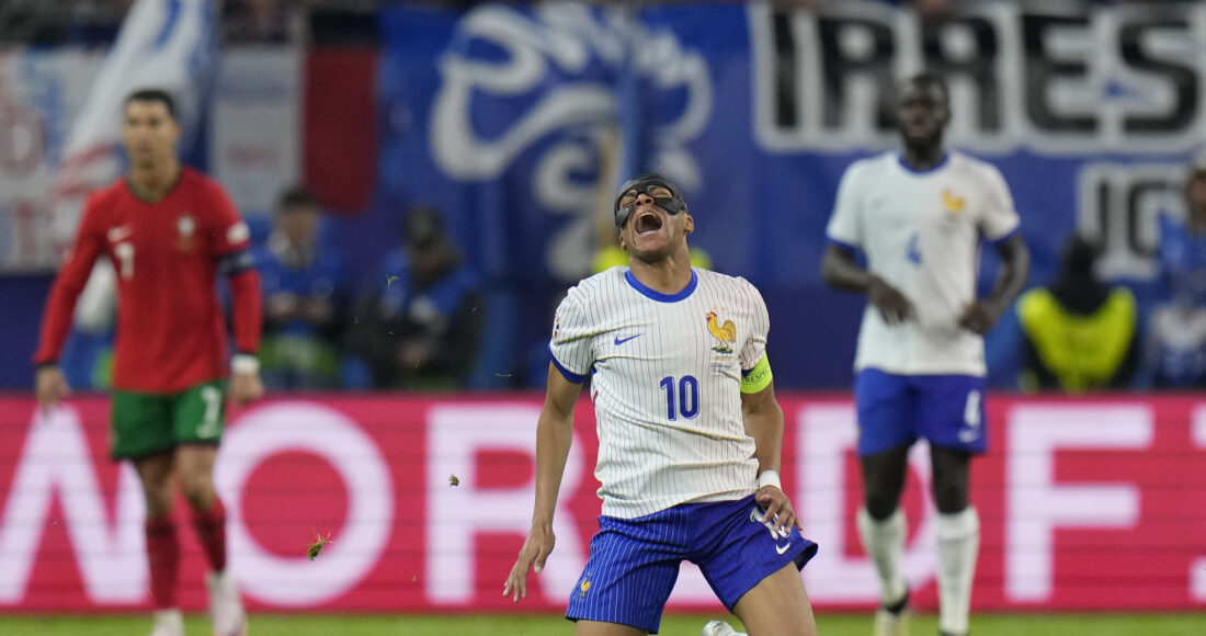 Kylian Mbappe ngã xuống sân sau va chạm với Joao Palhinha trong trận tứ kết Euro 2024, Hamburg ngày 5/7. Ảnh: AP