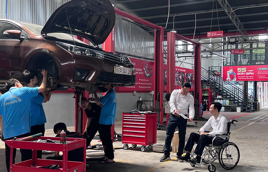 Nguyễn Ngọc Hà trao đổi công việc cùng đồng nghiệp tại gara sửa chữa ô tô do anh làm giám đốc. Ảnh: Diệp Phan