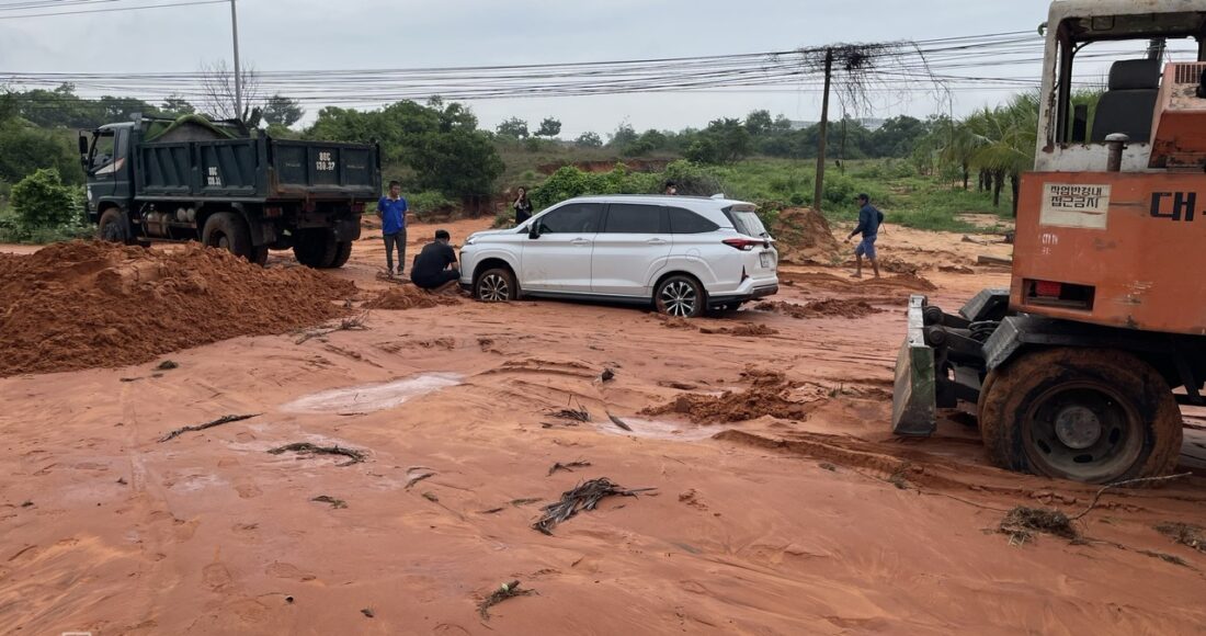 Một ôtô đi qua đường Phú Hài bị mắc kẹt trong bùn cát đỏ, sáng 27/7. Ảnh: Việt Quốc