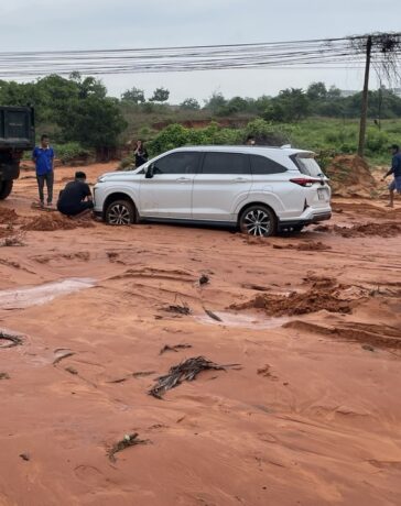 Một ôtô đi qua đường Phú Hài bị mắc kẹt trong bùn cát đỏ, sáng 27/7. Ảnh: Việt Quốc