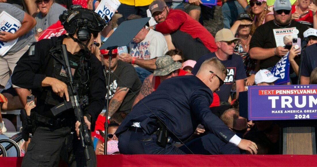 Nhân viên mật vụ Mỹ vây quanh ông Trump sau khi nghi phạm nổ súng hôm 13/7. Ảnh: AFP