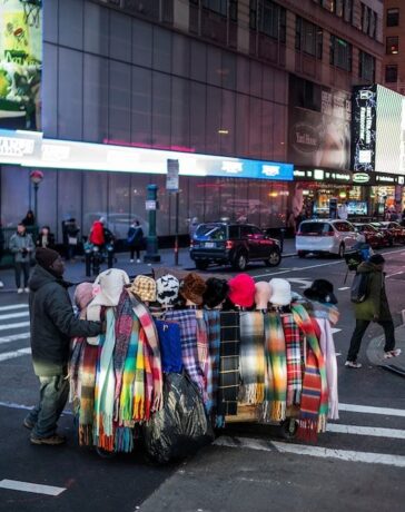 Một người bán hàng trên đường phố New York tháng 12/2023. Ảnh: Reuters