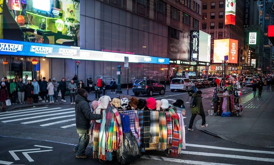 Một người bán hàng trên đường phố New York tháng 12/2023. Ảnh: Reuters