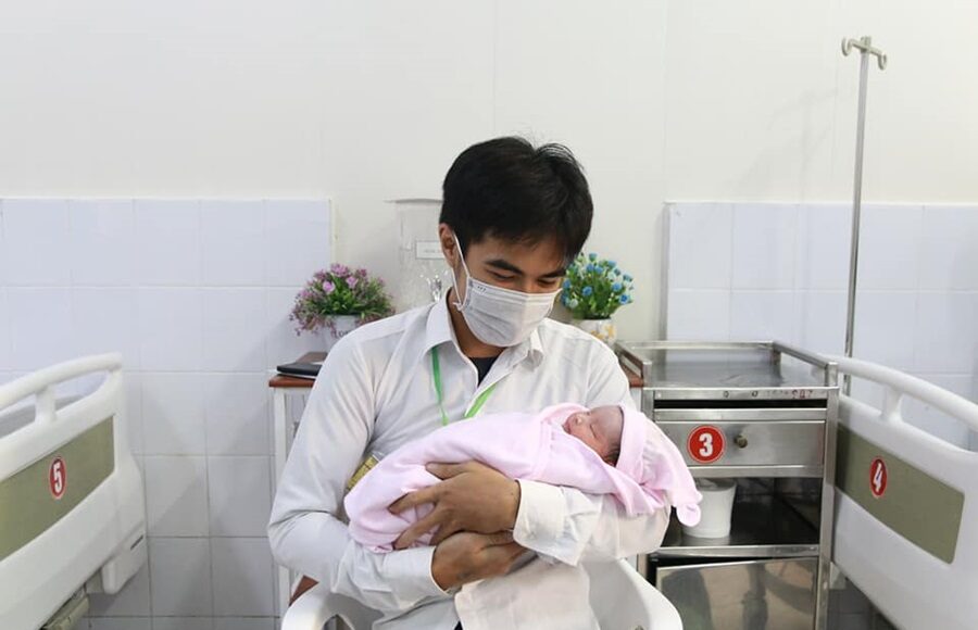 Tuấn Anh, con trai chị Thơm bế em sau khi mẹ sinh, tháng 12/2021. Ảnh: Nhân vật cung cấp