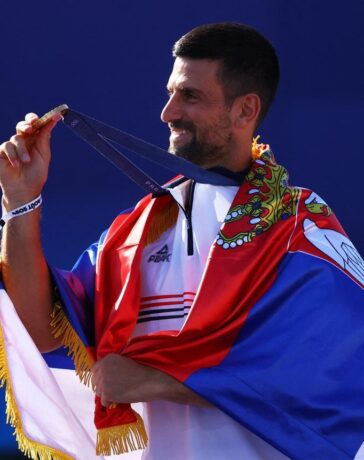 Djokovic khoác lá cờ Serbia, trên bục nhận HC vàng Olympic ở sân Philippe Chatrier, Paris hôm 4/8. Ảnh: Reuters