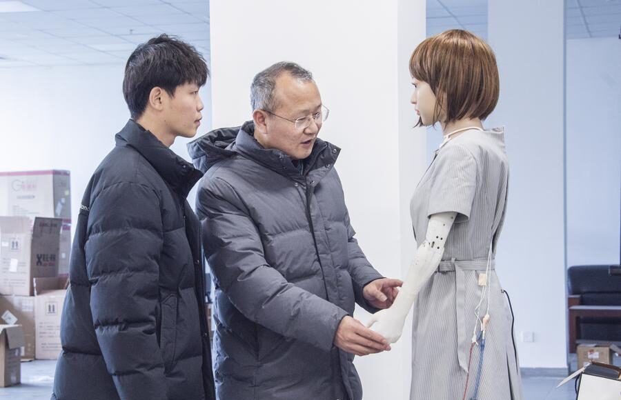 Giáo sư Liu Xiaofeng nói chuyện với một nghiên cứu sinh về robot hình người tại Đại học Hà Hải. Ảnh: Xinhua