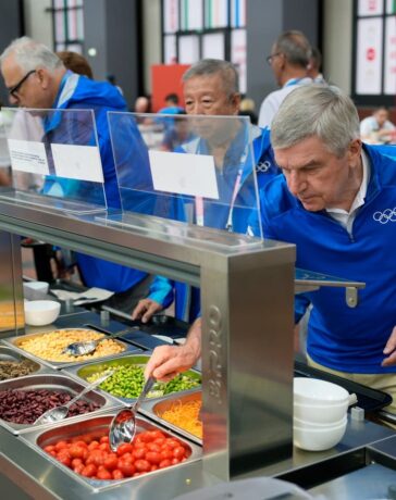Chủ tịch Ủy ban Olympic Quốc tế (IOC) lấy đồ ăn tại quầy salad trong làng VĐV Olympic Paris 2024. Ảnh: AP
