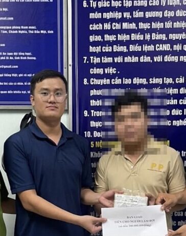 Anh Hòa và anh Tuấn trao trả lại số tiền nhặt được cho chủ nhân. Ảnh: Yên Khánh