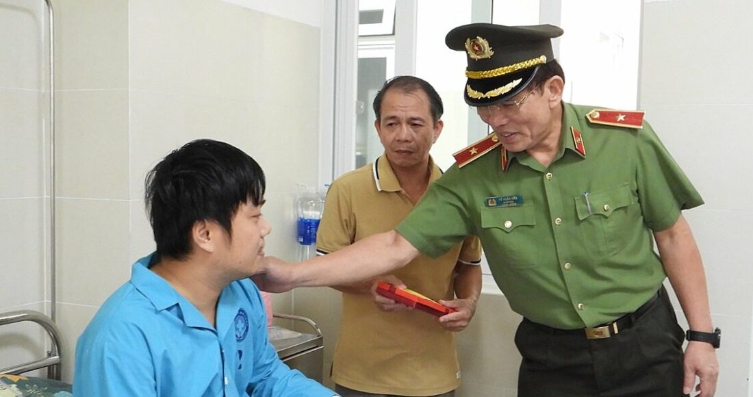 Một trong hai cán bộ công an bị Sách tấn công, bị thương ở tay được Giám đốc Công an TP Đà Nẵng thăm hỏi, động viên. Ảnh: Văn Hồ