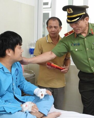 Một trong hai cán bộ công an bị Sách tấn công, bị thương ở tay được Giám đốc Công an TP Đà Nẵng thăm hỏi, động viên. Ảnh: Văn Hồ